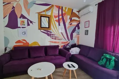 a living room with a purple couch and a table at Cypress Alley Amazing Apartment in Ulcinj