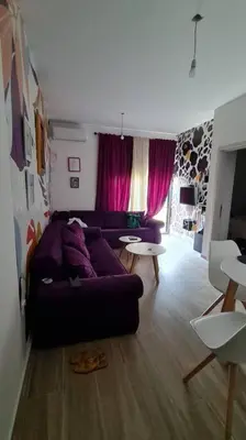 a living room with a purple couch and a table at Cypress Alley Amazing Apartment in Ulcinj