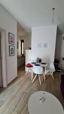 a living room with a table and chairs and a kitchen at Cypress Alley Amazing Apartment in Ulcinj