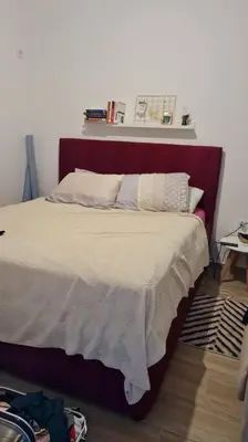 a bed with a red headboard in a bedroom at Cypress Alley Amazing Apartment in Ulcinj