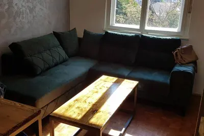 a green couch in a living room with a coffee table at Sophie's Emerald Studio apartment in Podgorica