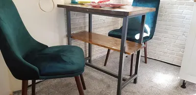 a desk with two chairs and a wooden table and a table and chairs at Sophie's Emerald Studio apartment in Podgorica