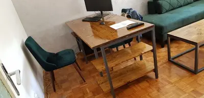 a living room with a table and a green couch at Sophie's Emerald Studio apartment in Podgorica