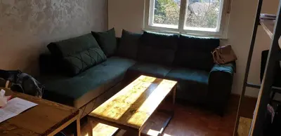 a living room with a green couch and a table at Sophie's Emerald Studio apartment in Podgorica