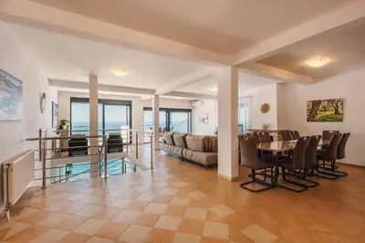 a living room with a table and a couch at Orange Villa - 7 Bedrooms - 5 Star Location - Views - Pool in Dobra Voda
