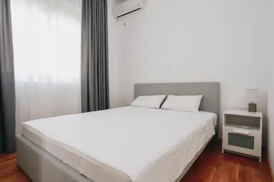 a bedroom with a large white bed and a window at Status-M Apartments Sunny Side in Becici