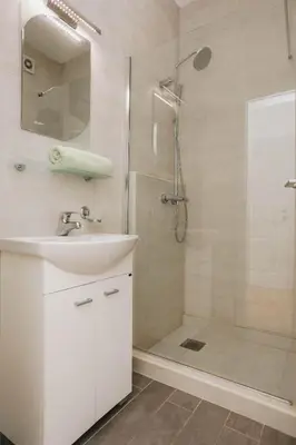 a white bathroom with a sink and a shower at Status-M Apartments Sunny Side in Becici