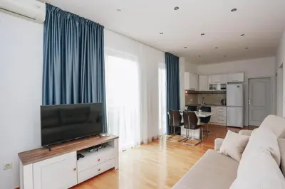 a living room with a couch and a flat screen tv at Status-M Apartments Sunny Side in Becici