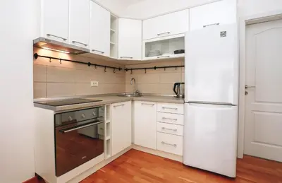 a kitchen with white cabinets and a refrigerator at Status-M Apartments Sunny Side in Becici