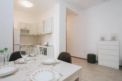 a white table with chairs and plates and wine glasses at Status-M Apartments Przno in Pržno