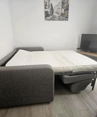 a bed sitting in a room with a tv at Status-M Apartments Przno in Pržno