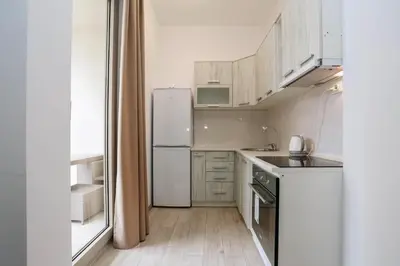 a small kitchen with white appliances and a window at Status-M Apartments Przno in Pržno