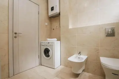 a bathroom with a washing machine and a sink at Status-M Apartments Przno in Pržno