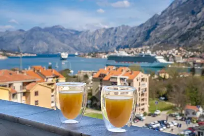 two glasses of beer sitting on a ledge at The view of Kotor - Sea & Old town view in Kotor