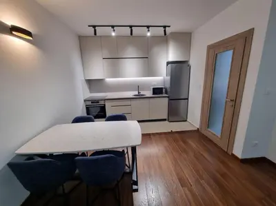 a kitchen with a table and chairs in a room at Master Quart modern apt. 27 in Podgorica