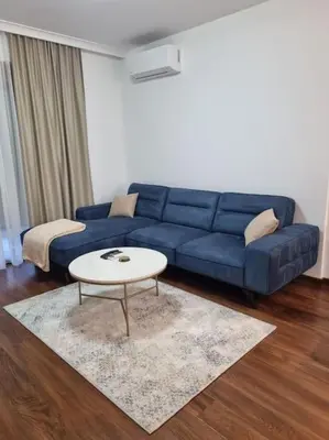 a living room with a blue couch and a table at Master Quart modern apt. 27 in Podgorica
