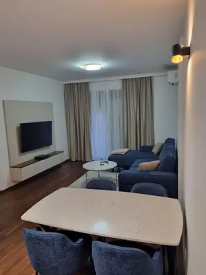 a living room with a couch and a table and chairs at Master Quart modern apt. 27 in Podgorica