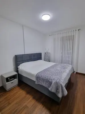 a bedroom with a bed and a night stand at Master Quart modern apt. 27 in Podgorica