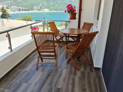 a balcony with a table and chairs and a view of the ocean at Apartment AS in Čanj