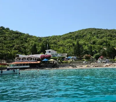 a boat in the water next to a beach at Apartment AS in Čanj