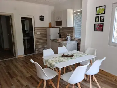 a kitchen and dining room with a table and chairs at Apartment AS in Čanj