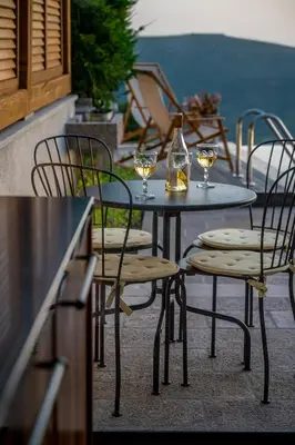 a table and chairs with wine glasses on a patio at Villa Di Campagna in Kotor