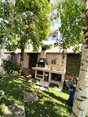a woman standing in front of a backyard with a grill at Apollon home apartments in Bar