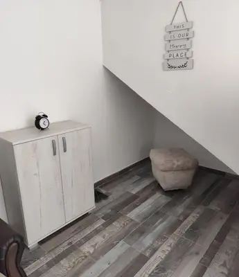 a room with a staircase with a cabinet and a stool at Apollon home apartments in Bar