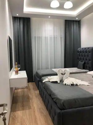a bedroom with two beds with black drapes at Apartments Long Beach in Ulcinj