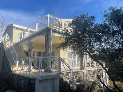 a white house with a balcony on the side of it at Villa Thetis in Bigovo