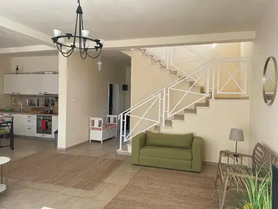 a living room with a staircase and a green couch at Villa Thetis in Bigovo