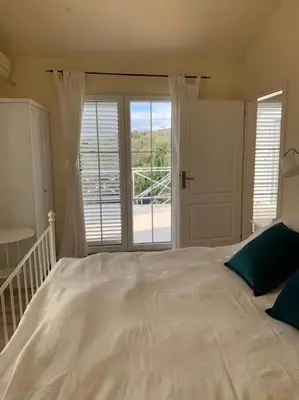 a bedroom with a large white bed and a window at Villa Thetis in Bigovo