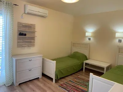 a small bedroom with two beds and a green blanket at Villa Thetis in Bigovo