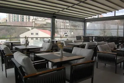 a restaurant with tables and chairs and a large window at Status-M Apartments 100 in Becici