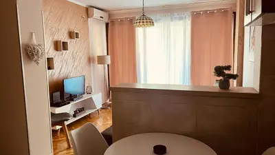 a living room with a desk and a television in a room at Majdini Clock Tower Apartman in Podgorica