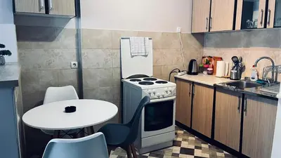 a small kitchen with a table and a stove at Majdini Clock Tower Apartman in Podgorica
