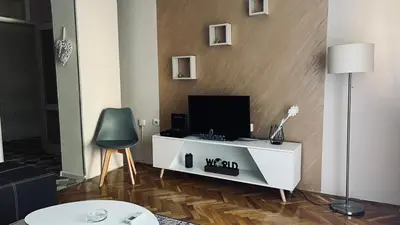 a living room with a tv on a white cabinet at Majdini Clock Tower Apartman in Podgorica