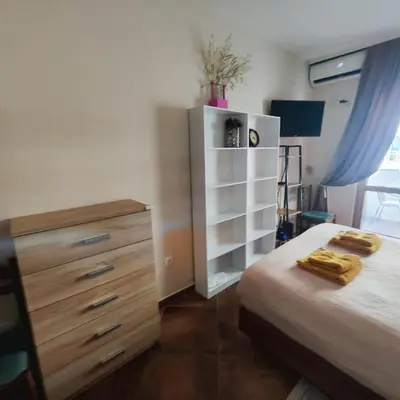 a bedroom with a bed and a dresser with towels on it at Studio 75 meters to the sea in Rafailovici