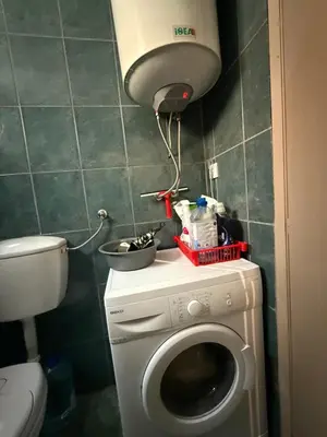 a small bathroom with a washing machine and a lamp at Studio 75 meters to the sea in Rafailovici