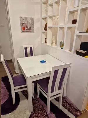 a white dining room table with two chairs and shelves at Your place in Podgorica in Podgorica