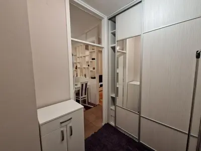 a kitchen with white cabinets and a walk in closet at Your place in Podgorica in Podgorica