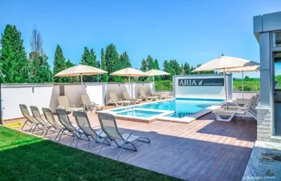 a pool with chairs and umbrellas on a patio at Ulcinj apartman 