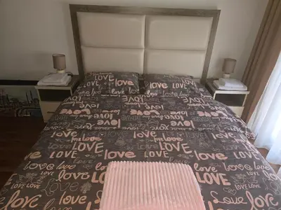 a bedroom with a bed with a brown comforter at Ulcinj apartman 