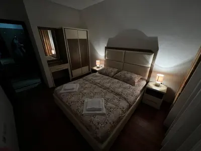a bedroom with a large bed with two lamps on it at Ulcinj apartman 