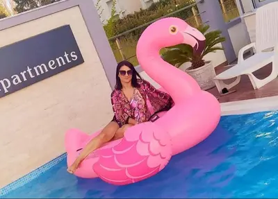 a woman sitting on an inflatable pink flamingo in a pool at Ulcinj apartman 