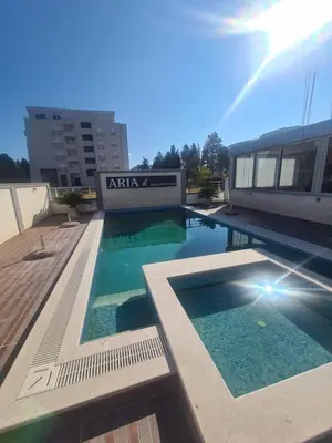 a swimming pool in front of a building at Ulcinj apartman 