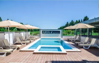a swimming pool with lounge chairs and umbrellas at Ulcinj apartman 