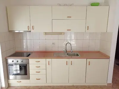 a kitchen with white cabinets and a sink at Apartment Kotor in Kotor