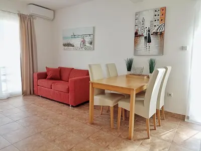 a dining room with a table and a red couch at Apartment Kotor in Kotor
