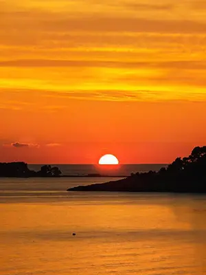 a sunset over the ocean with the sun in the sky at Beachfront luxury apartment in Budva